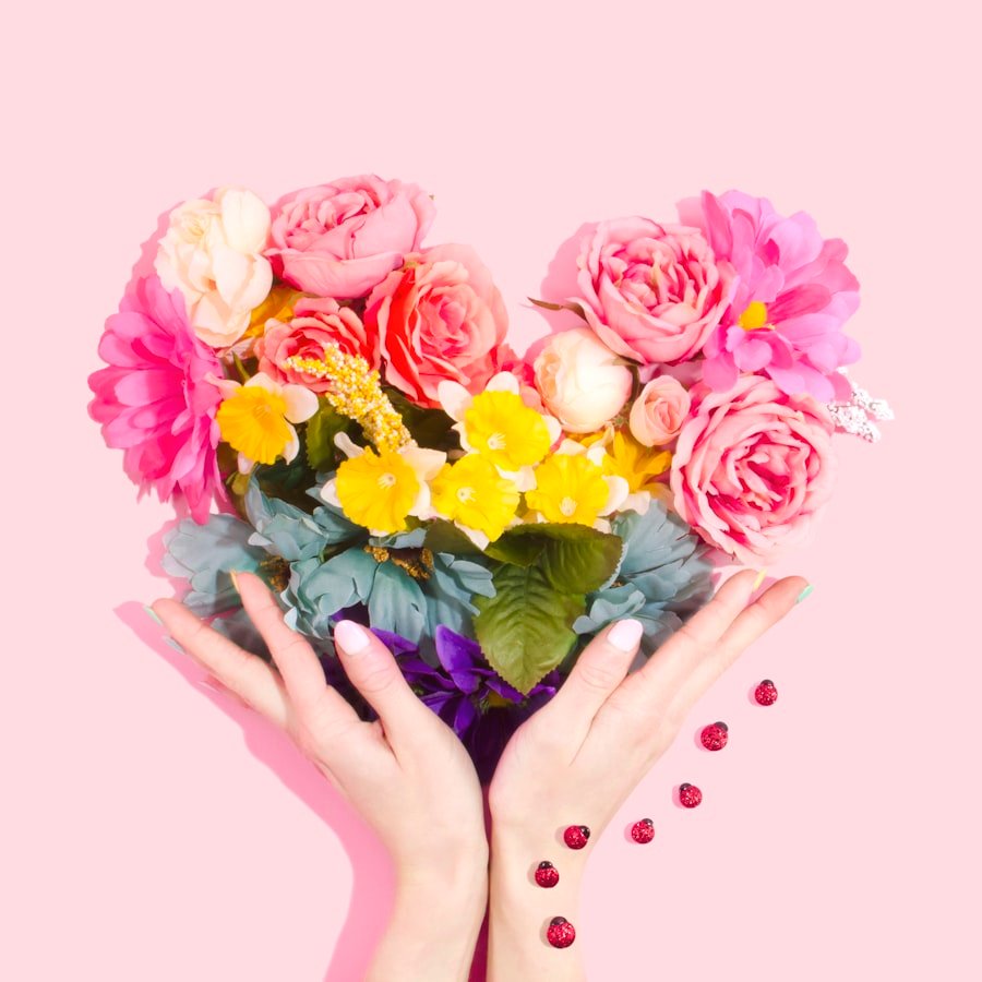 Hands cradling a heart of pink blooms